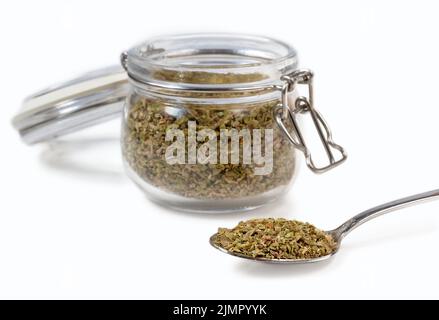 Oregano spice in a glass jar on a white background. Stock Photo