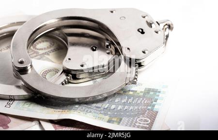Croatian kuna currency. Police handcuffs on Croatian kuna banknotes. Currency exchange, concept of economic crime in Europe. Stock Photo