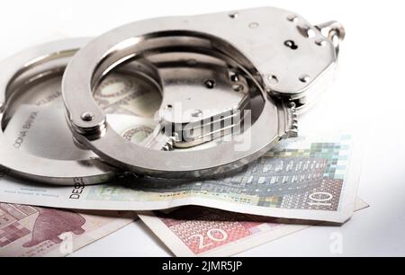 Croatian kuna currency. Police handcuffs on Croatian kuna banknotes. Currency exchange, concept of economic crime in Europe. Stock Photo