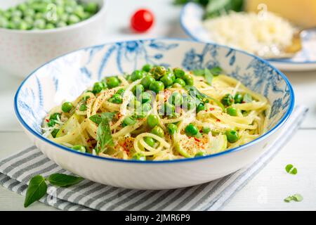 Spaghetti with zucchini and green peas. Stock Photo