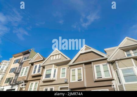 Sloped suburban houses with beige and light brown exterior in San Francisco, California. Complex houses with gable roofs along with the multi-storey a Stock Photo