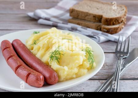Mashed potatoes and sausages on the old wooden background. Stock Photo