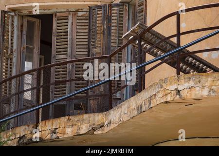 Broken woodne window and balcony of an abandoned house in the Ghost Resort City of Varosha Famagusta, Cyprus Stock Photo
