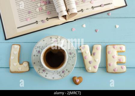Top view of gingerbread letters Love, a cup of coffee and an open book. Stock Photo