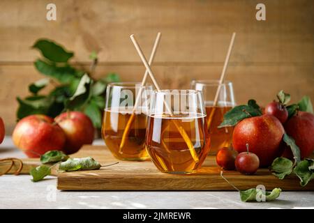 Apple juice in a glass and fresh fruits with leaves Stock Photo