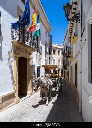 RONDA, ANDALUCIA, SPAIN - MAY 8 : Tourists enjoying a ride in a horse drawn carriage in Ronda Spain on May 8, 2014. Three uniden Stock Photo