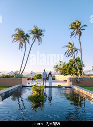 Couple man and woman in swimming pool of there lodge on vacation in South Africa looking out over mountains near Hermanus Stock Photo