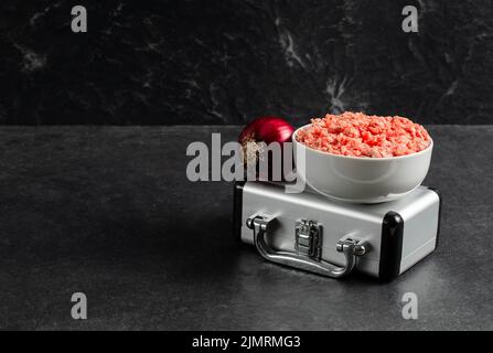 Plate with fresh ground beef, silver suitcase, red onion on a grey black background, stock photo Stock Photo