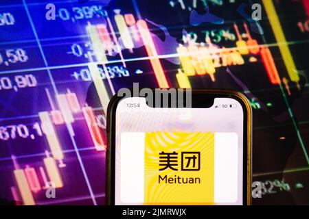 KONSKIE, POLAND - August 07, 2022: Smartphone displaying logo of Meituan Chinese shopping platform on stock exchange diagram background Stock Photo