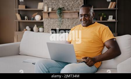 African senior businessman freelancer adult male american consumer man teacher coach talking to webcam video conference calling in virtual chat waving Stock Photo