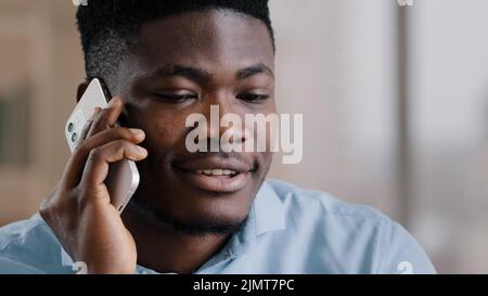 African american happy businessman guy talk on cellphone gadget communicate friendly with partner professional young male investor hold modern device Stock Photo