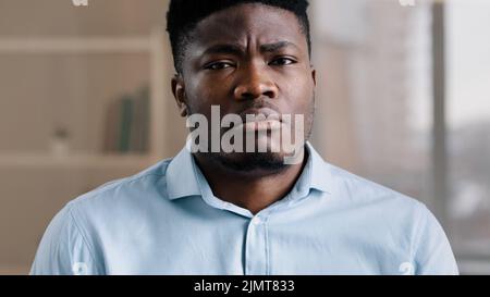 Close up male portrait of confused shocked african american millennial 30s man young adult guy worker feel displeasure dissatisfied emotion aversion Stock Photo