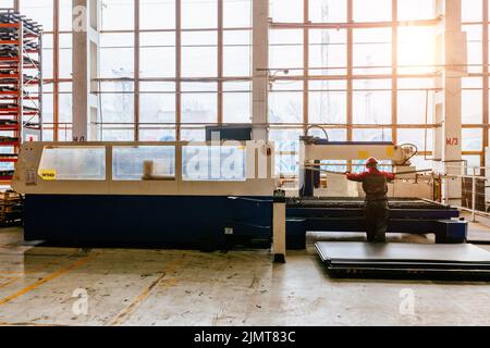 Operator works with CNC laser cutting machine Stock Photo