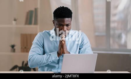 Frustrated shocked african businessman american adult man student work on computer make error mistake feels stress upset with bad news failure e Stock Photo