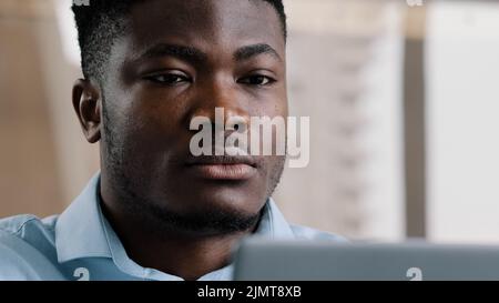 Close up exhausted young millennial african businessman overworked man massaging dry irritable eyes feeling eyestrain discomfort headache fatigue Stock Photo