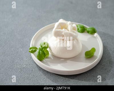 Burrata cheese on plate, copy space. Gray background Stock Photo