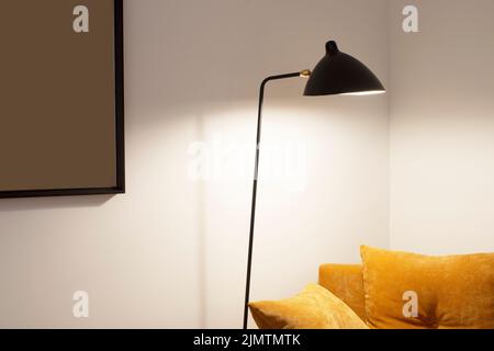 Reading corner with camel velvet cushions and black design lamp Stock Photo