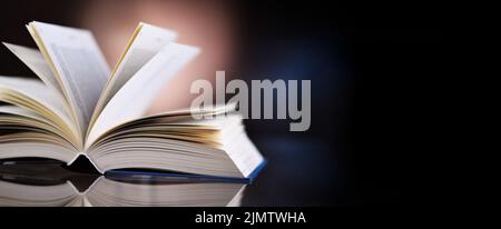 An open hardcover book lying on a table Stock Photo