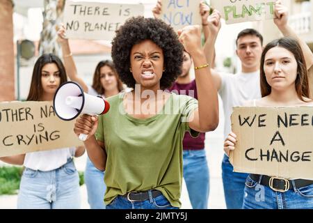 Group of young friends protesting and giving slogans at the street annoyed and frustrated shouting with anger, yelling crazy with anger and hand raise Stock Photo