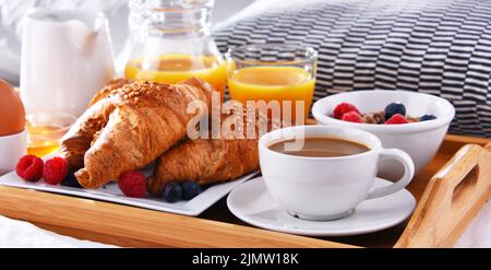 A tray with breakfast on a bed in a hotel room. Stock Photo