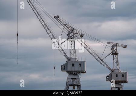 construction cranes of the shipyard on the Neva River in St. Petersburg in cloudy weather Stock Photo