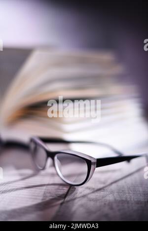 Composition with glasses and open book on the table. Stock Photo