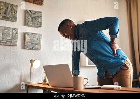 Back pain, ache and sore body with a business man suffering from bad posture. Feeling hurt with cramp or stiff spine from being overworked. Young male Stock Photo