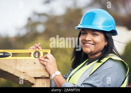 Everything has to be level. Cropped portrait of an attractive young female construction worker working on site. Stock Photo