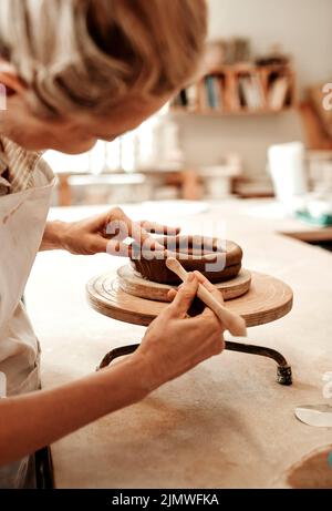 I fell in love with making pottery. a female artisan working in her pottery workshop. Stock Photo