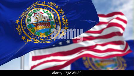 The New Hampshire state flag waving along with the national flag of the United States of America Stock Photo