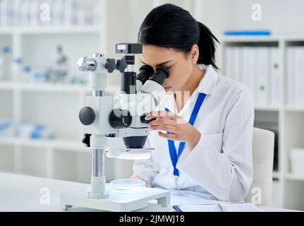 Medical research done right. a young scientist using a microscope in a laboratory. Stock Photo