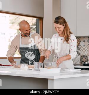 Where youll find the sweetest couples. a happy mature couple baking together at home. Stock Photo