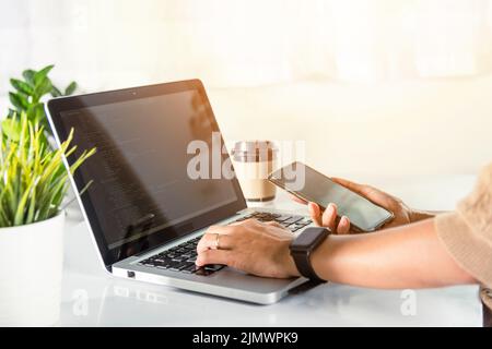 Software developer hands typing data coding programming javascript with laptop computer and mobile phone, Programmer woman looking smartphone program Stock Photo