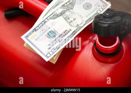 Red jerry fuel can and dollar bills closeup Stock Photo