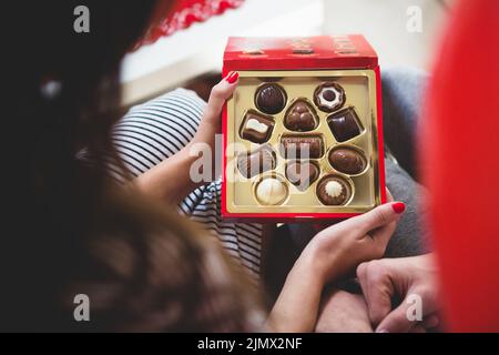 Woman opening box chocolates Stock Photo