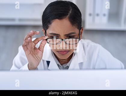 This cant be right... an attractive young female scientist looking stressed while working in her laboratory. Stock Photo