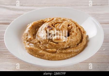 Fresh homemade peanut butter made of roasted peanuts, salt, honey and olive oil isolated on white background Stock Photo