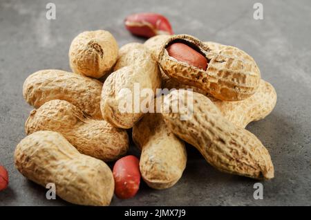 Ripe organic Peanuts in shell on stone table. Healthy eating concept Stock Photo