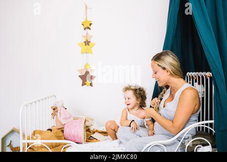Cheerful pregnant mother baby bed Stock Photo