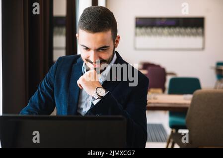 Cheerful elegant man using laptop Stock Photo