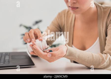 Close up woman taking pills office Stock Photo