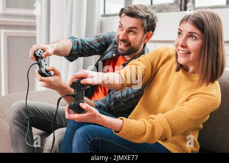Beautiful couple playing video games console Stock Photo