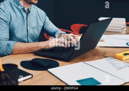 These hands are creative. an unrecognizable male architect using a laptop while working in his office. Stock Photo