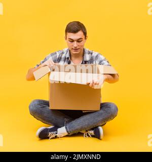 Front view man opening delivered package Stock Photo