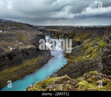 Autumn snowfall on picturesque waterfall Sigoldugljufur  view. Season changing in southern Highlands of Iceland. Stock Photo