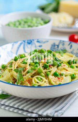 Spaghetti with zucchini and green peas. Stock Photo