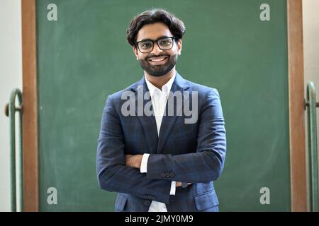 Smiling young indian business man wearing suit standing in office. Portrait Stock Photo