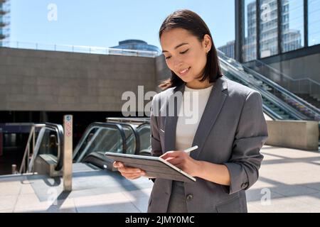 Young Asian woman entrepreneur standing in subway using digital tablet. Stock Photo