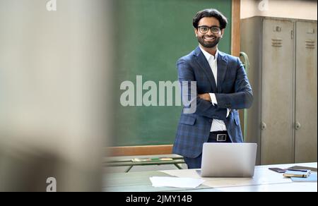 Happy young indian business man teacher wearing suit posing for portrait. Stock Photo