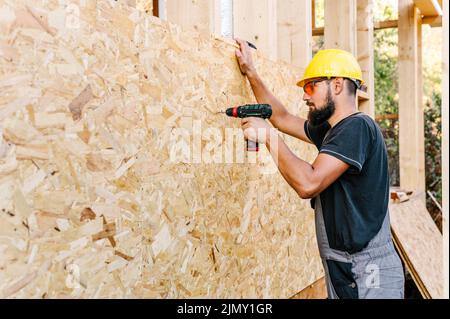 Side view construction worker drilling plywood with copy space Stock Photo